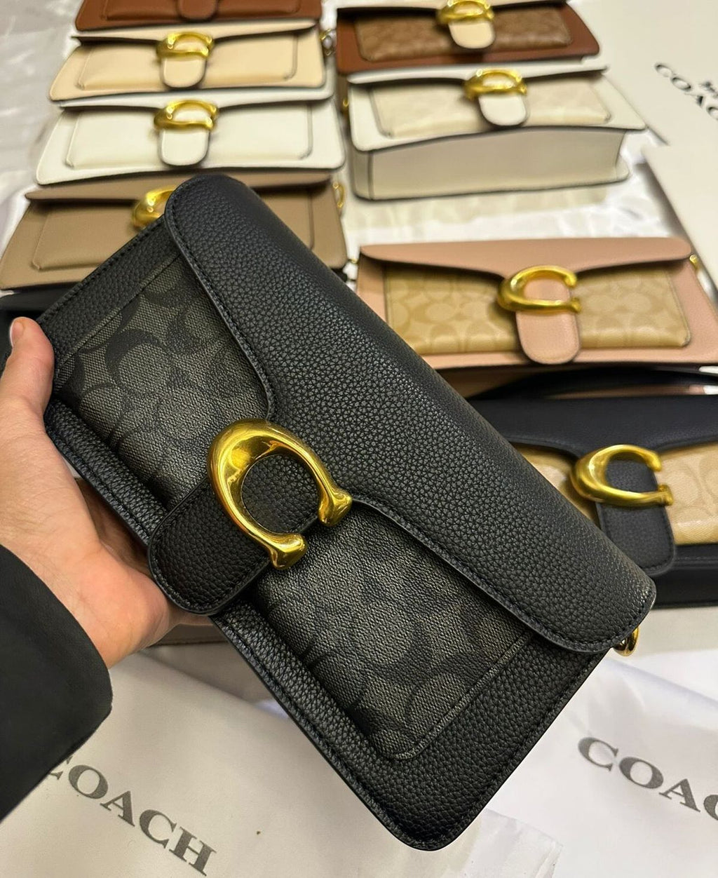 Black structured crossbody bag with gold-tone clasp and adjustable strap