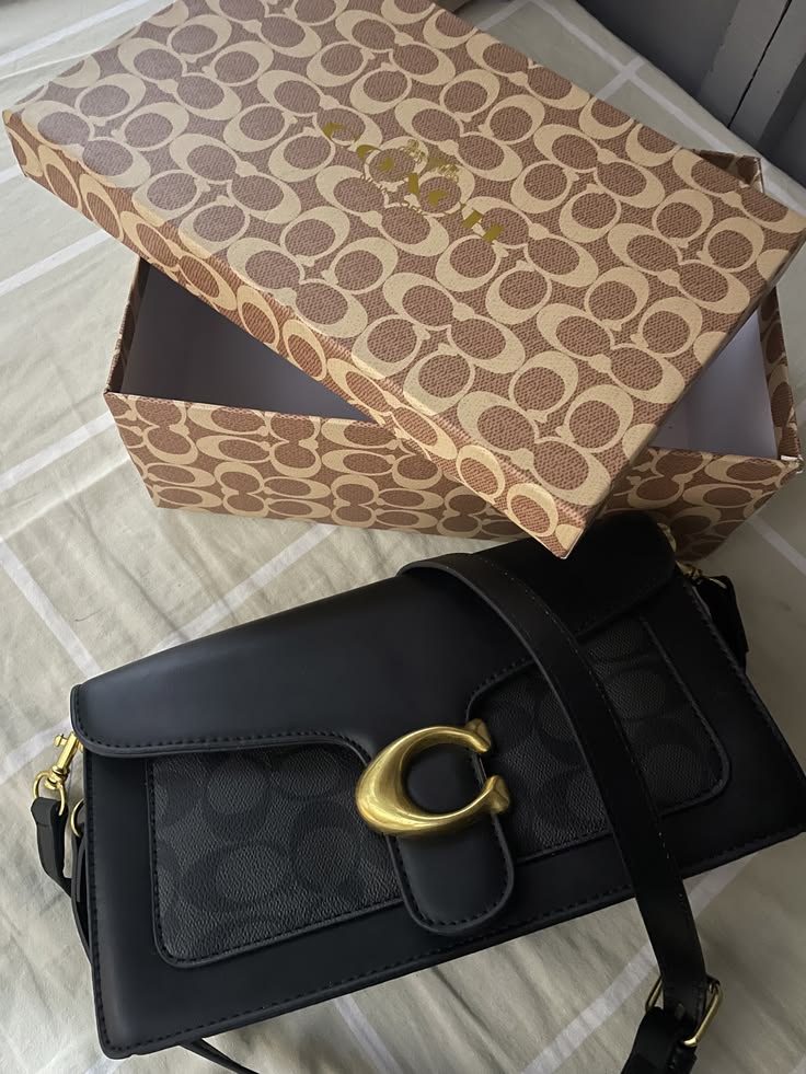 Close-up of black crossbody bag with gold-tone clasp
